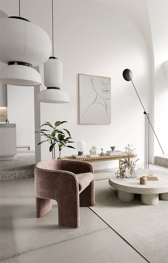 17 a refined minimalist living room done in pure neutrals and accented with a lovely mauve velvet chair that adds a soft touch