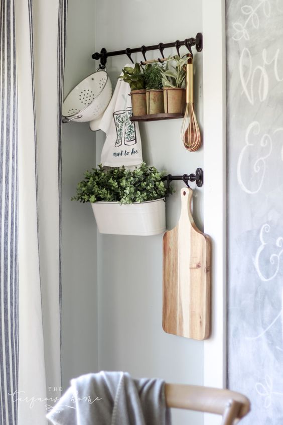 rustic kitchen wall decor with railings, potted greenery, a cutting board, some vintage kitchen stuff is chic