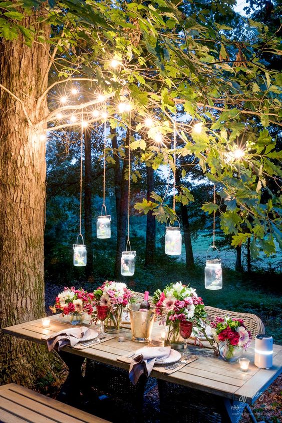 25 string lights on the branches and pendant jar lanterns over the table plus candles on the table is very welcoming