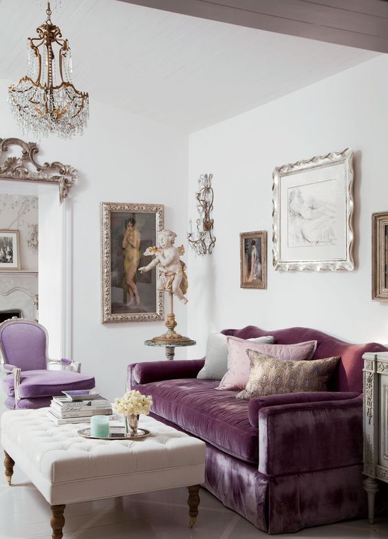 a sophisticated neutral living room with a purple sofa and a lilac chair, a creamy tufted ottoman and a very exquisite gallery wall