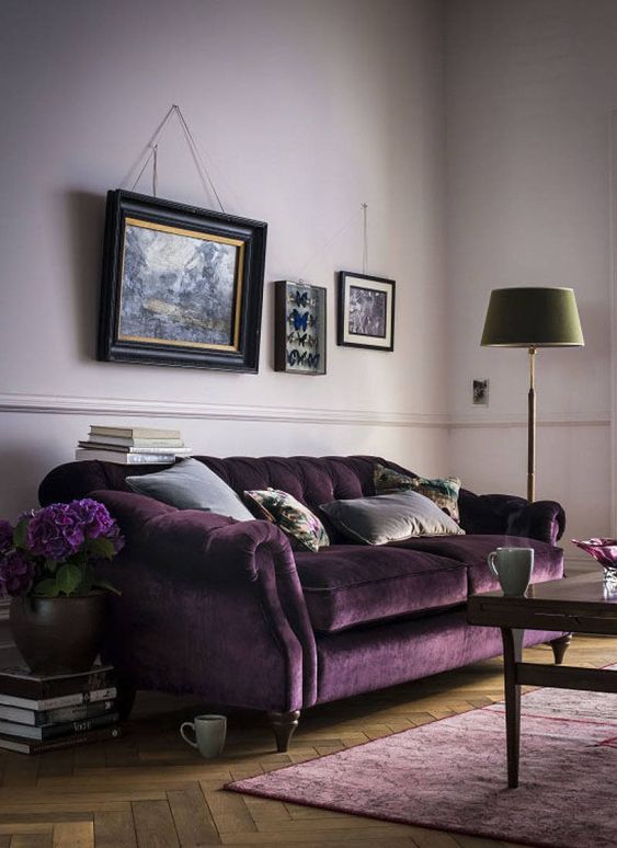 37 a welcoming living room with lilac walls, a refined purple velvet sofa, a lilac rug, a vintage gallery wall, a green floor lamp and a dark stained table