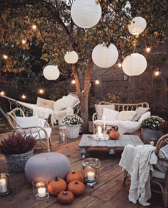 a welcoming backyard with candle lanterns, strign lights over the space and paper lamps is amazing and cozy