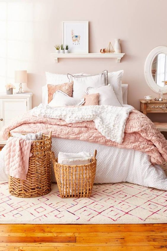 42 a lovely bedroom with a blush wall, neutral and stained furniture, baskets, a floatign shelf and pink textiles