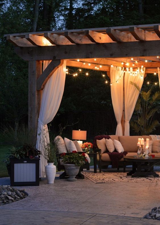 string lights, floor lamps and candles on the table make this outdoor living room very welcoming and very chic