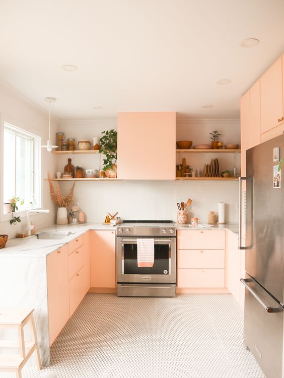 a modern blush pink kitchen with white stone countertops, built-in shelves and potted plants is chic and cool