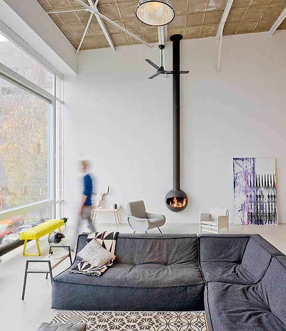 a contemporary living room with a glazed wall, a grey low sofa, a suspended hearth, some pretty furniture is very cool