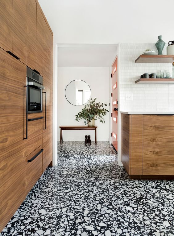 a gorgeous black and white terrazzo floor from entryway to the kitchen connects these spaces and adds interest to them