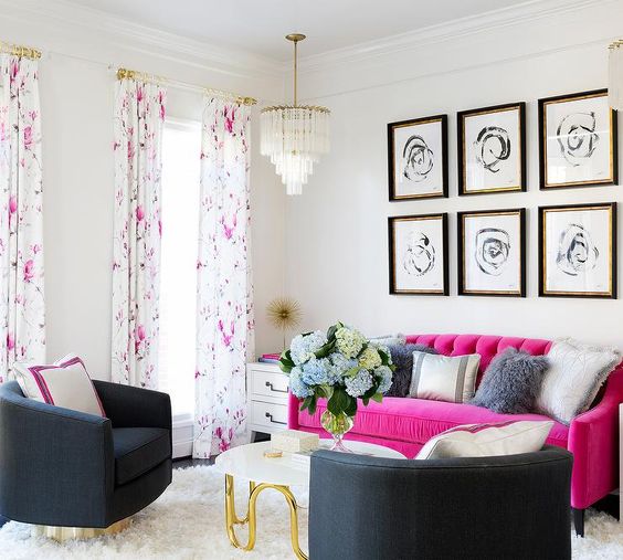 a modern living room with black chairs, a hot pink sofa, a grid gallery wall, a chic chandelier and floral curtains