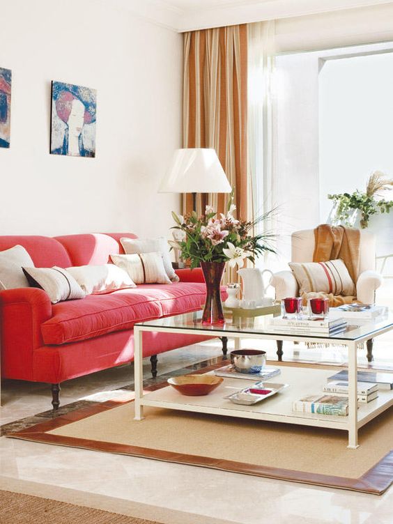 a vivacious living room with a red sofa, neutral furniture, a cool lamp, a lovely gallery wall and striped curtains