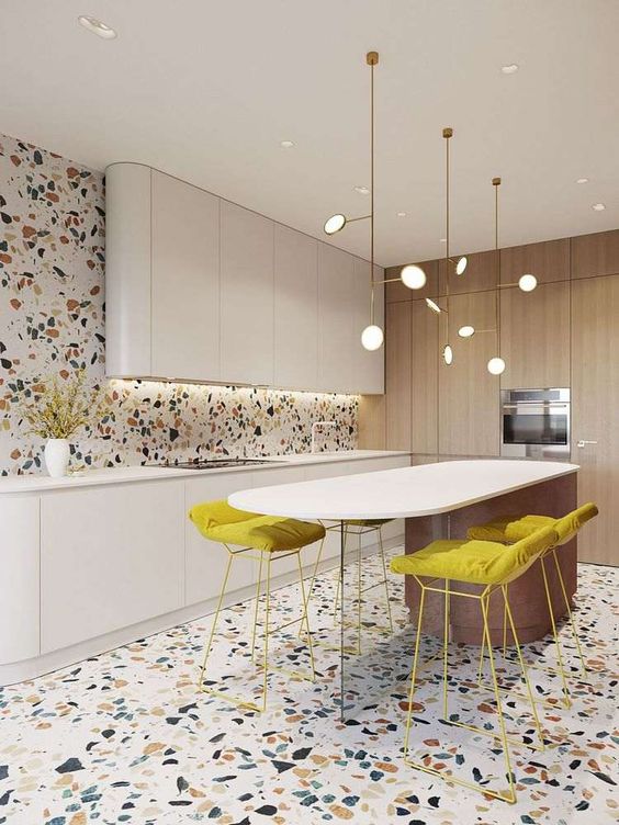 Colorful terrazzo on the floor and wall adds interest and fun to this ultra minimalist and refined kitchen