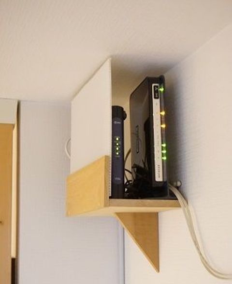 a mini shelf attached right under the ceiling will elegantly hide your router and will merge with the color of the walls and ceiling