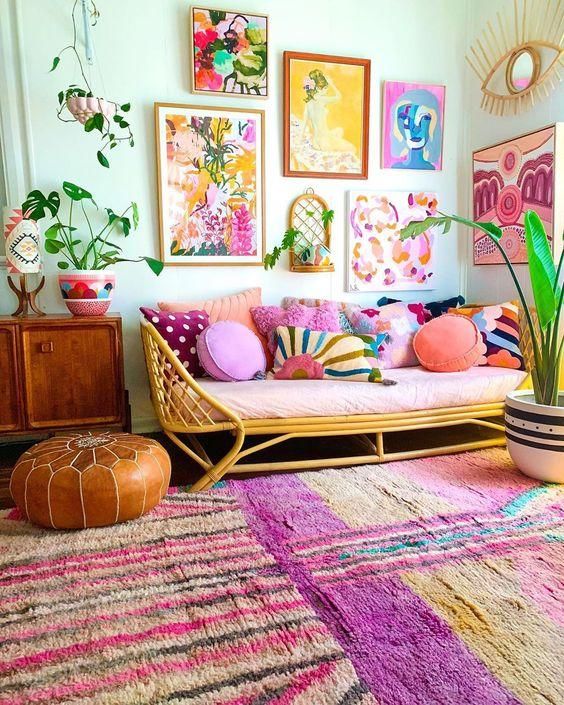 a colorful living room with bright rugs, a bright gallery wall, a colorful sofa with pillows and potted plants