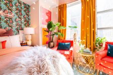 a colorful maximalist bedroom with a floral accent wall, a red chair and mustard curtains, a disco ball and a neon light plus bright bedding