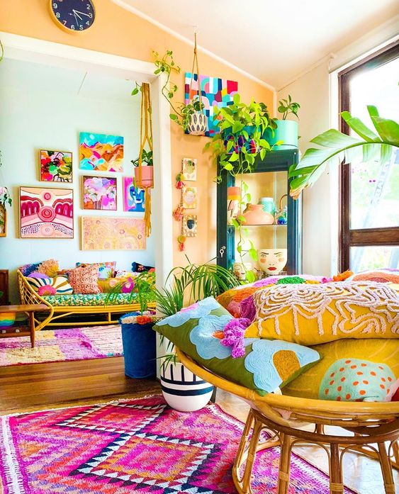 a colorful maximalist space with rattan furniture, colorful accessories and textiles plus bright gallery walls is super fun