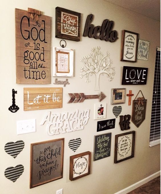 a farmhouse gallery wall with various signs and artworks, arrows, keys, hearts and words is very chic and cool