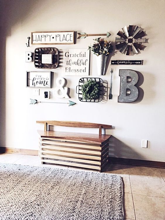 a lovely farmhouse gallery wall with signs in frames, a metal monogram, some potted blooms and metal elements