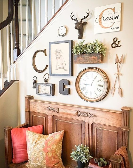 a lovely gallery wall with a clock, some artworks, monograms, potted greenery and faux taxidermy is a stylish solution