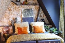 a maximalist attic bedroom with botanical walls and a black one, a navy bed, a coral ottoman, bright bedding and shelves