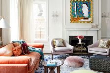 a maximalist living room with a coral sofa, a bold blue rug, pastel ottomans, lilac chairs and a bold artwork