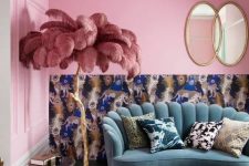 a maximalist living room with pink walls and printed wallpaper, a green sofa, gilded tables and bold pillows