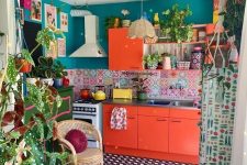 a maximalist space withh emerald walls, red cabinets, a colorful tile backsplash and artworks plus a tiled floor and plants