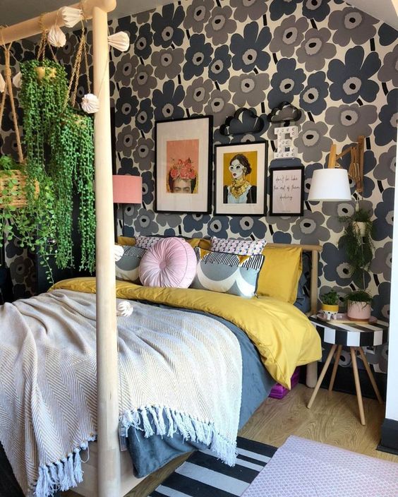a mid-century modern maximalist bedroom with a floral accent wall, a wooden bed with a stand for hanging plants and a striped stool