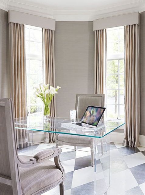 a refined and sleek home office with neutral walls and matching curtains, a sheer desk and refined upholstered chairs
