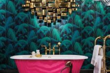 a refined maximalist bathroom with a tropical accent wall, a hot pink bathtub, a gold artwork, chic chandeliers and a black and white chervon floor