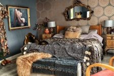 a sophisticated maximalist bedroom with an accent printed wall, wooden furniture, dark printed textiles, a vintage mirror and a crystal chandelier