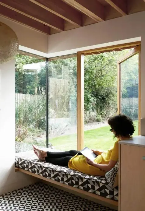a corner window with a daybed and printed bedding allows natural light, views and even an exit to the garden