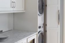22 a neutral laundry with shaker style kitchen cabinets, neutral stone countertops and much storage space is lovely