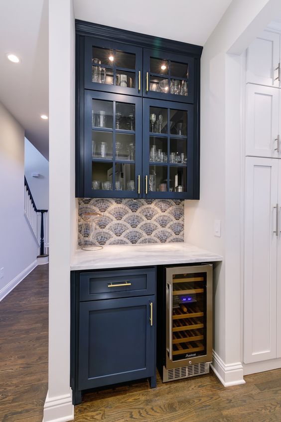 a tiny home bar done with a couple of navy kitchen cabinets and squeezed into a tiny awkward nook is lovely and has all the necessary stuff