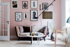 a gorgeous scandinavian living room with a pink wall