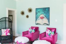 a bold and whimsical living room with a patterned ceiling, hot pink chairs and stools, a bold printed artwork and a bold printed rug