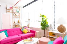 a colorful attic living room with a hot pink sofa, turquoise chairs, colorful and fun pillows, a potted plant and a blush pouf