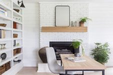 a cool modern country home office with a white brick fireplace, a large storage unit, a desk and a bold rug, potted plants