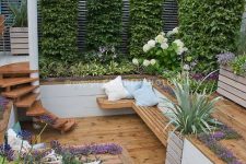 a creative sunken patio with living walls, greenery and blooms around, steps and a bench for sitting is a cool way to make use of a small space
