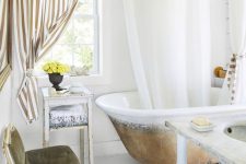 a fancy bathroom with white planked walls and a floor, a vintage bathtub, vintage and refined furniture, a striped curtain looks wow