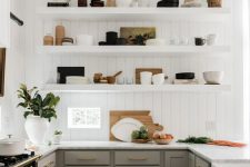 a modern English country kitchen with white planked walls, grey shaker style cabinets, open shelves, gold touches and potted plants