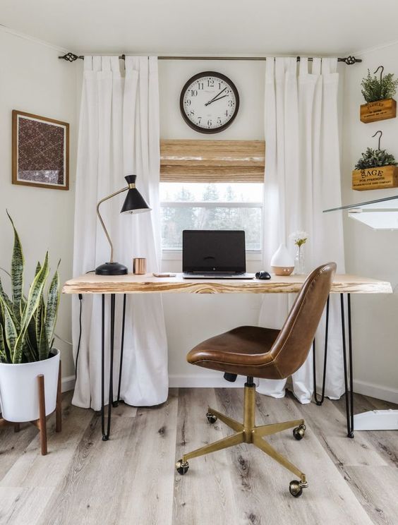 a modern country home office in creamy shades, with a hairpin desk, a leather chair, creamy curtains and potted plants on the floor and wall