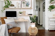 a modern country home office with floating shelves and a hairpin desk, a leather chair, a wooden stool and potted plants