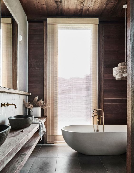 a modern country style bathroom with stained walls and a ceiling, a large wall-mounted vanity, stone sinks and a lovely bathtub