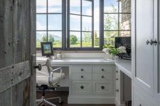 a modern farmhouse home office with French windows, a white shared desk, a leaher chair and wooden beams