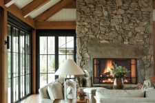 a cozy living room with a large stone fireplace