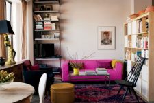 a moody apartment with an industrial feel, blush walls and a black ceiling, a hot pink sofa for a bold color statement