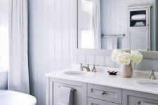 a neutral bathroom design with a planked wall