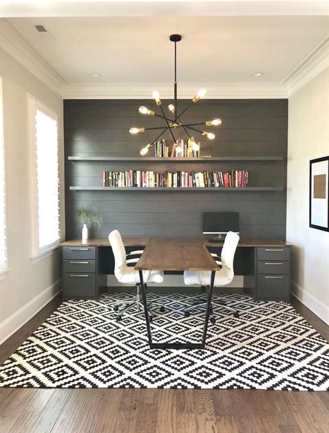 a stylish modern country home office with a grey planked wlal and a unique double desk with an additional center desktop for workign together