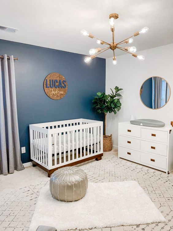 a stylish modern nursery with a blue wall