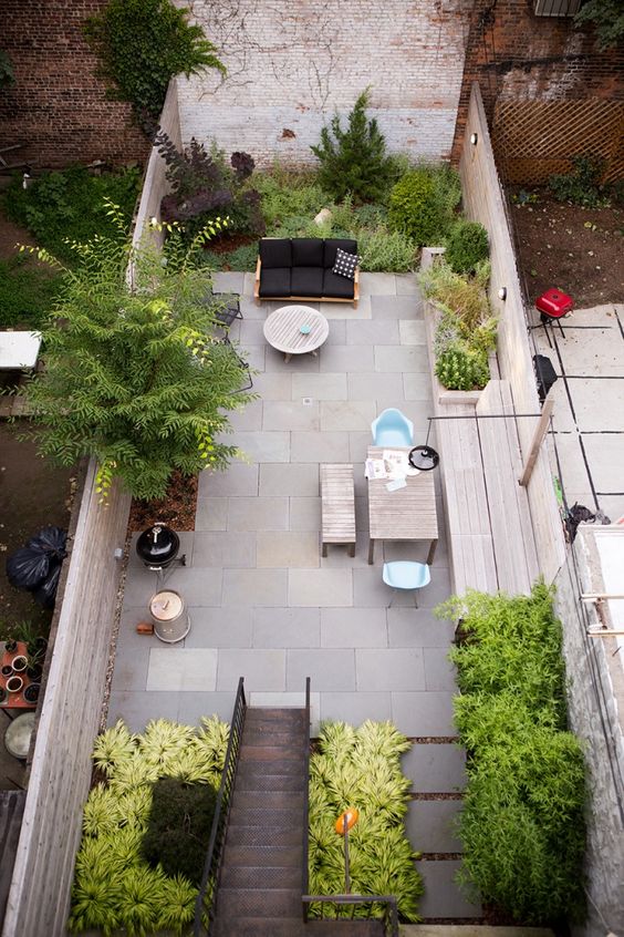 a sunken patio with growing and potted plants, with a living and dining space is very welcoming and stylish