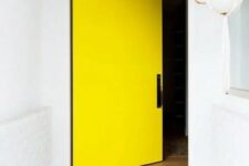 a white entrance with a concrete floor and an oversized yellow square front door are amazing to highlight the exterior of your home